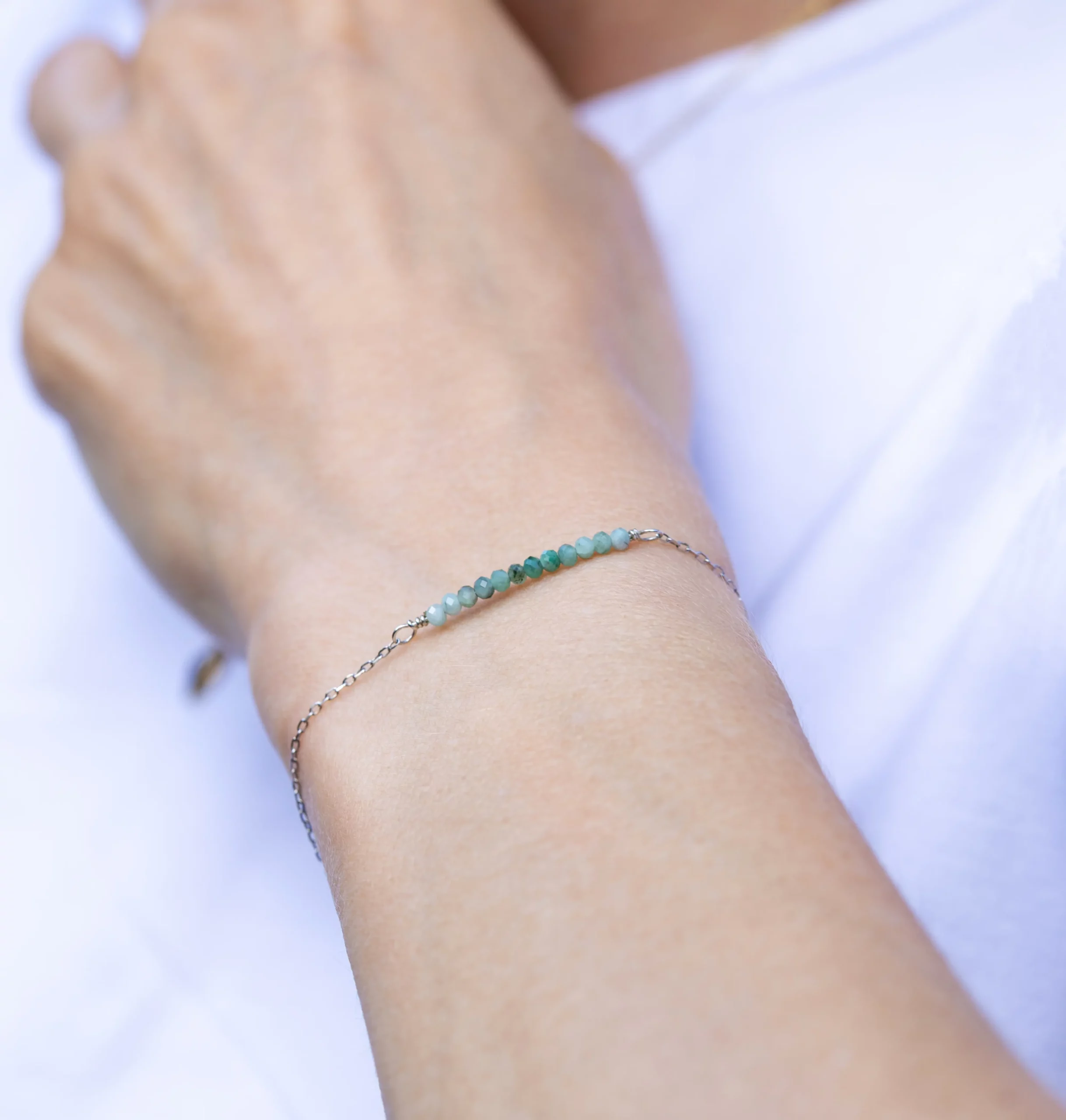 Bransoletka srebrna z kolekcji Minimal ze szmaragdami na modelce.