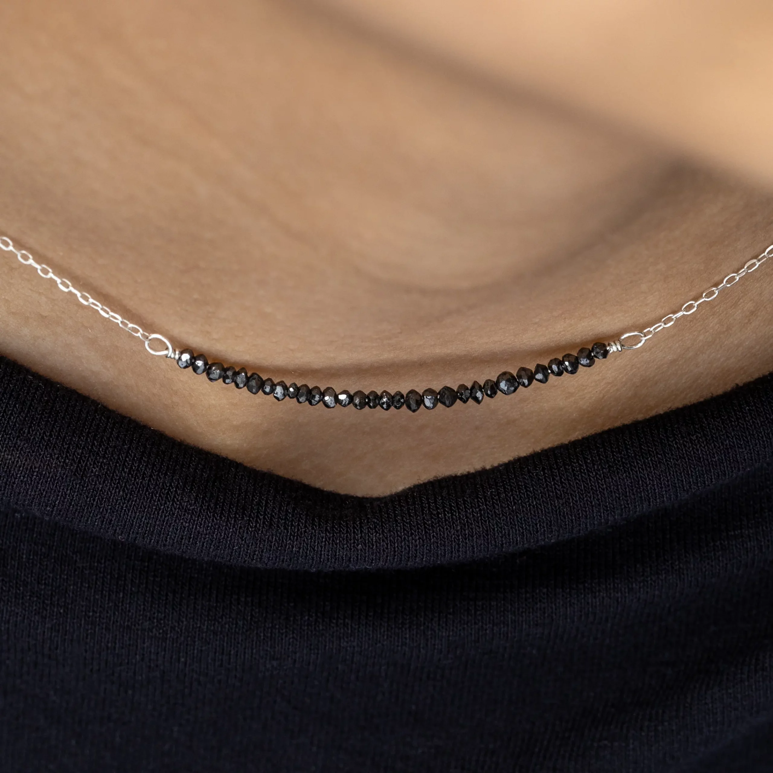 Naszyjnik srebrny Minimal Black Diamond z naturalnymi czarnymi diamentami na modelce - zbliżenie.