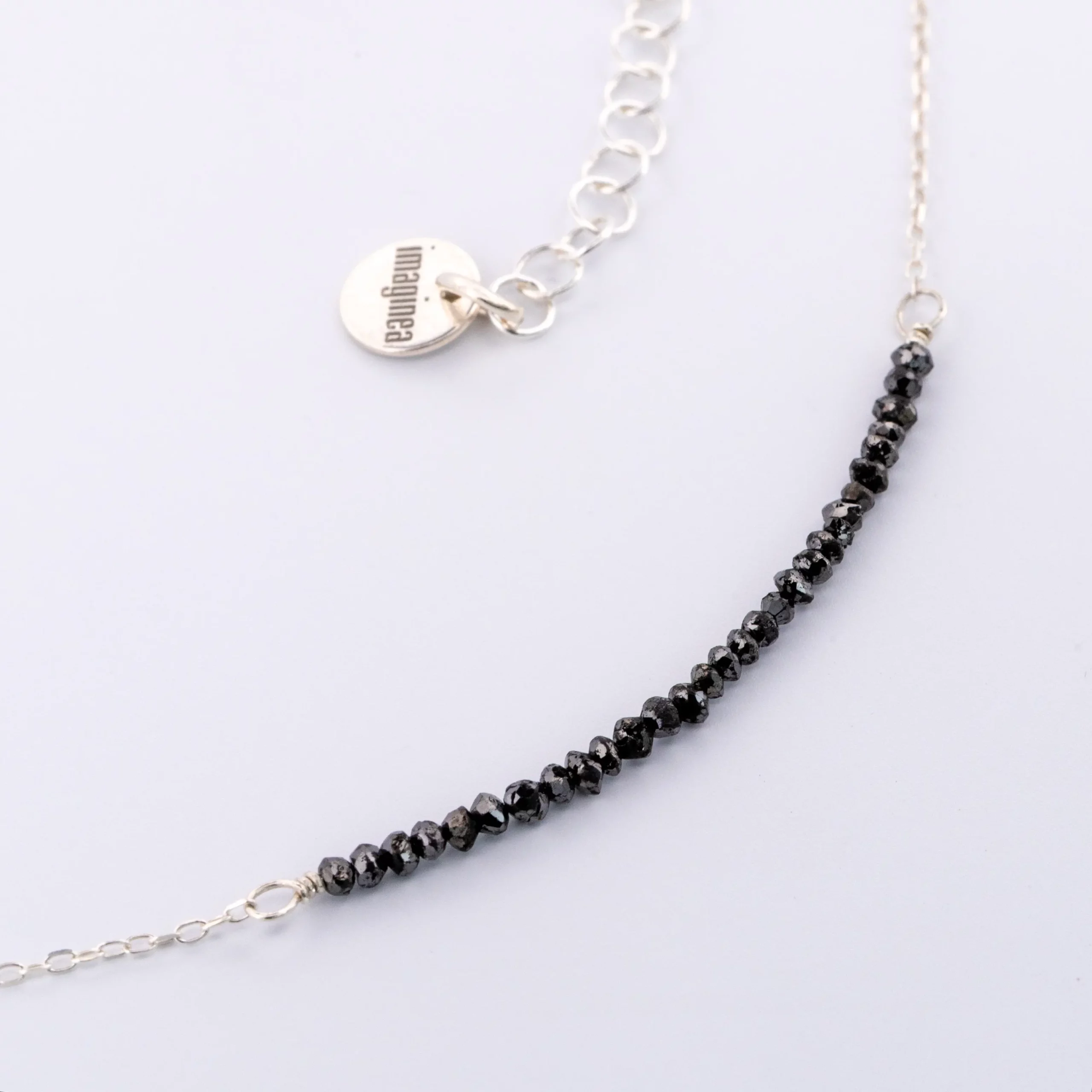 Detal naszyjnika Minimal Black Diamond z czarnymi diamentami.